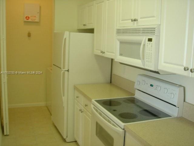 kitchen featuring white cabinetry and white appliances