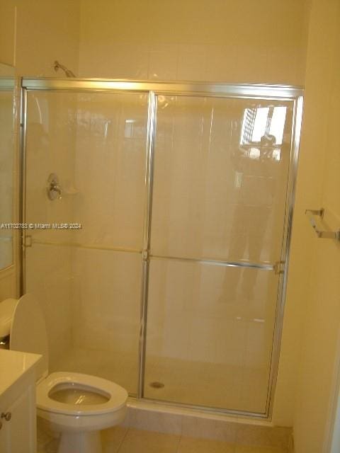 bathroom featuring tile patterned floors, vanity, toilet, and walk in shower