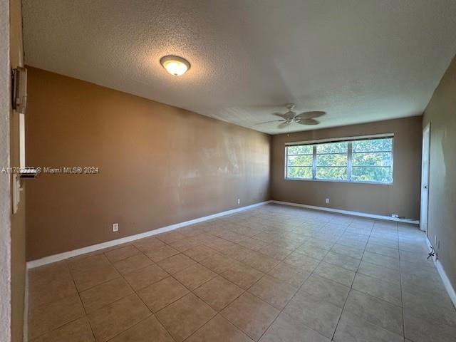 spare room featuring a textured ceiling and ceiling fan