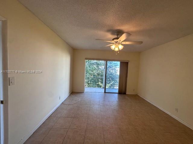 spare room featuring ceiling fan and a textured ceiling