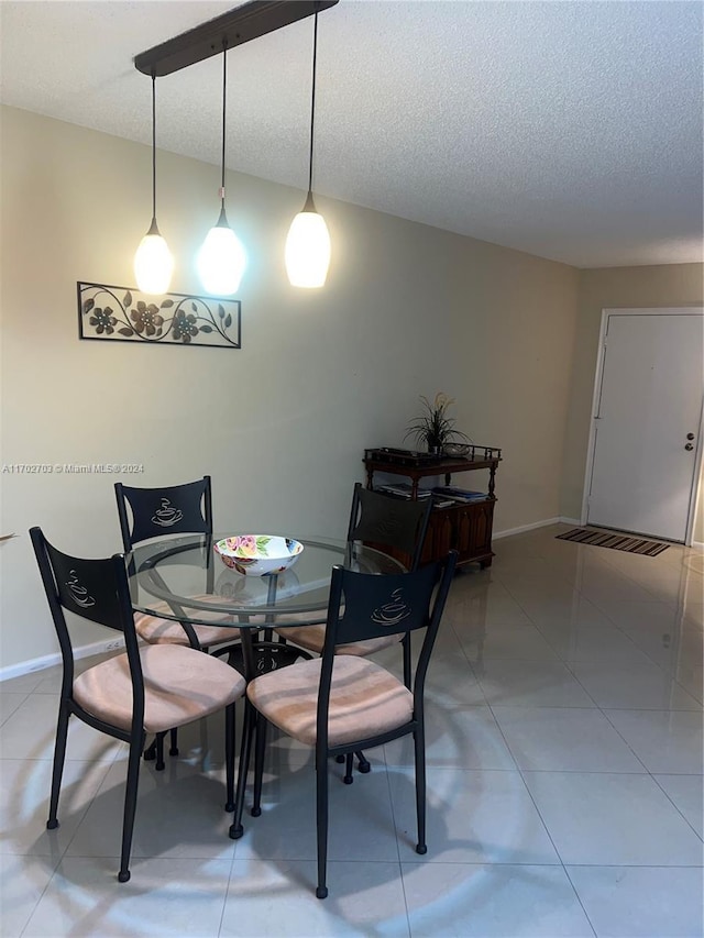 dining area featuring tile patterned flooring and a textured ceiling