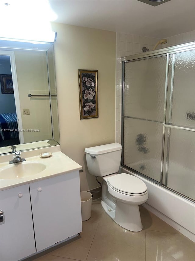 full bathroom with shower / bath combination with glass door, vanity, tile patterned floors, and toilet