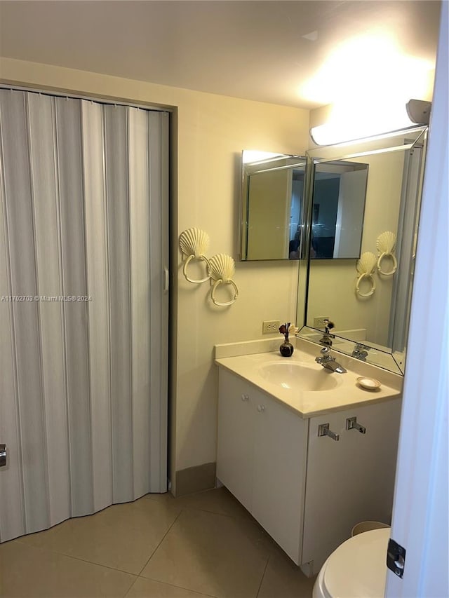 bathroom featuring tile patterned floors, vanity, and toilet