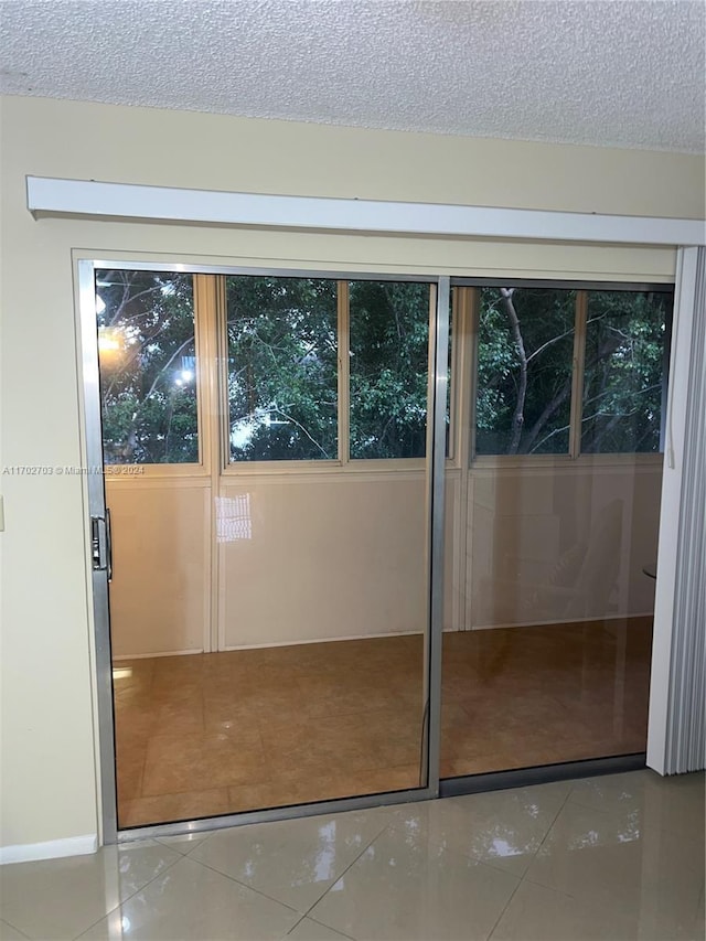 doorway to outside featuring a textured ceiling