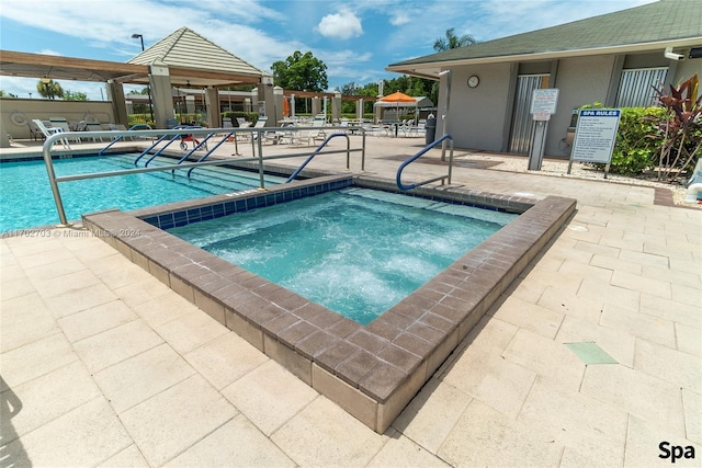 view of swimming pool with a gazebo, a patio area, and a hot tub