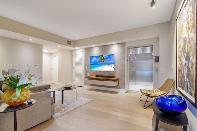 living room featuring light wood-type flooring and elevator