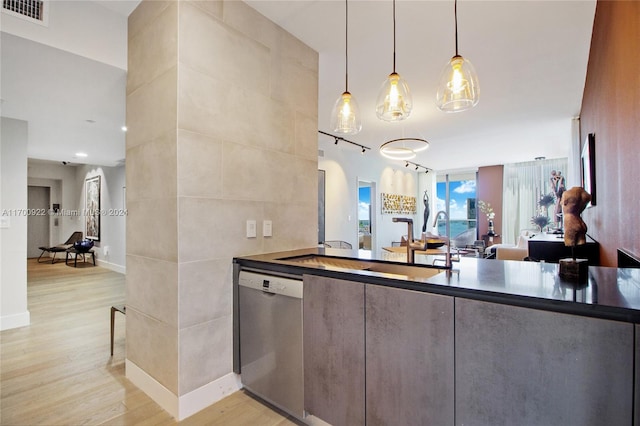 kitchen with stainless steel dishwasher, decorative light fixtures, tile walls, and light hardwood / wood-style flooring