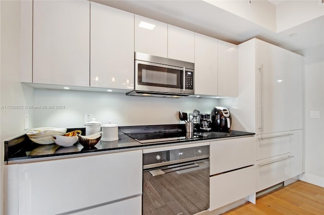 kitchen featuring white cabinets, light wood-type flooring, and appliances with stainless steel finishes