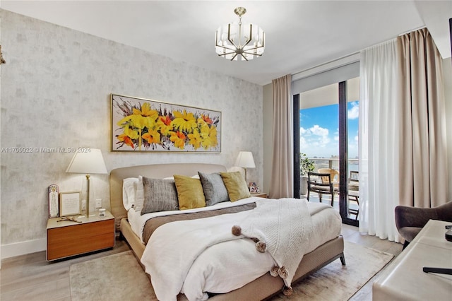 bedroom featuring an inviting chandelier, access to exterior, floor to ceiling windows, and light hardwood / wood-style flooring