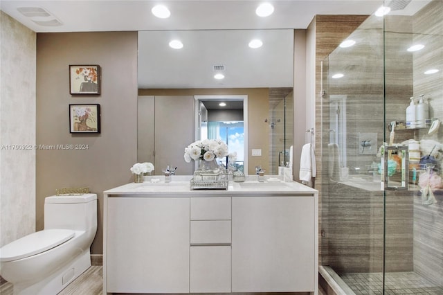 bathroom with vanity, toilet, and a shower with shower door