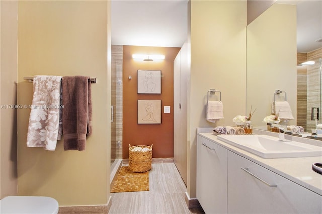 bathroom with vanity, a shower with shower door, and toilet