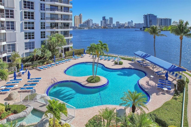 view of pool with a water view and a patio area