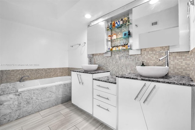 3530 Mystic Pointe Dr Unit 2907, Aventura, FL 33180 - full bathroom with two vanities, a bath, and decorative backsplash