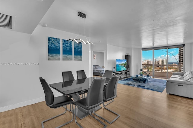 dining space featuring hardwood / wood-style floors and expansive windows