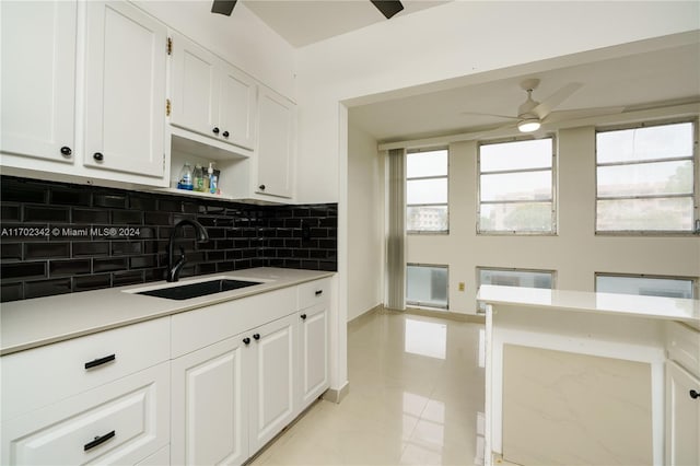 kitchen with ceiling fan, sink, light tile patterned floors, tasteful backsplash, and white cabinets