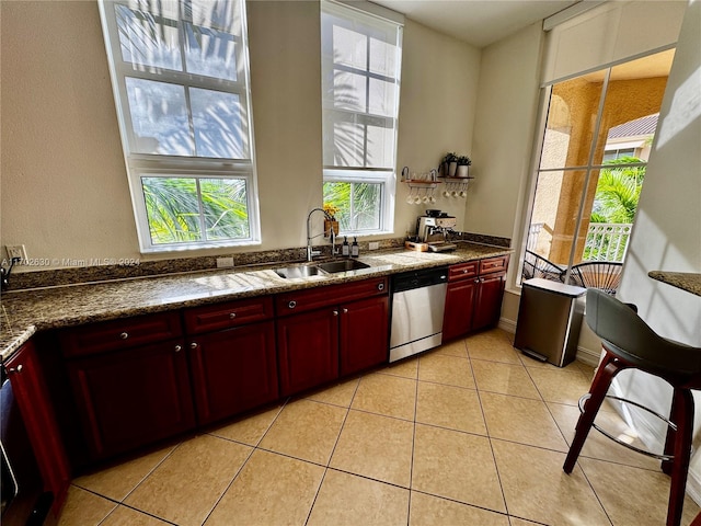 kitchen featuring stainless steel dishwasher, light tile patterned floors, and sink