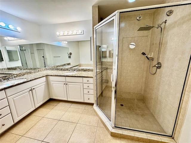 bathroom featuring tile patterned floors, a shower with door, and vanity