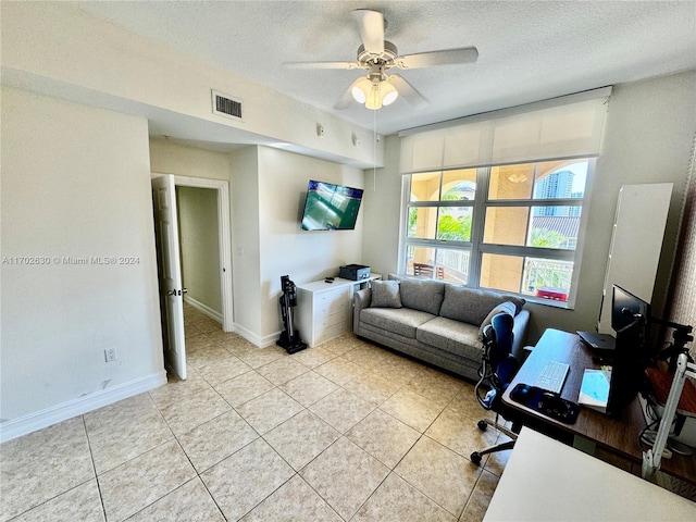 tiled office space featuring a textured ceiling and ceiling fan