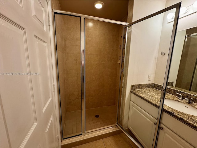 bathroom featuring tile patterned flooring, vanity, and walk in shower