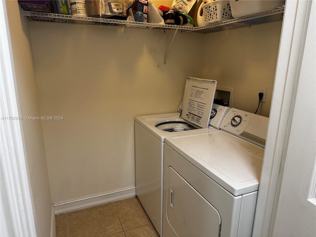 laundry area featuring light tile patterned floors and washing machine and clothes dryer