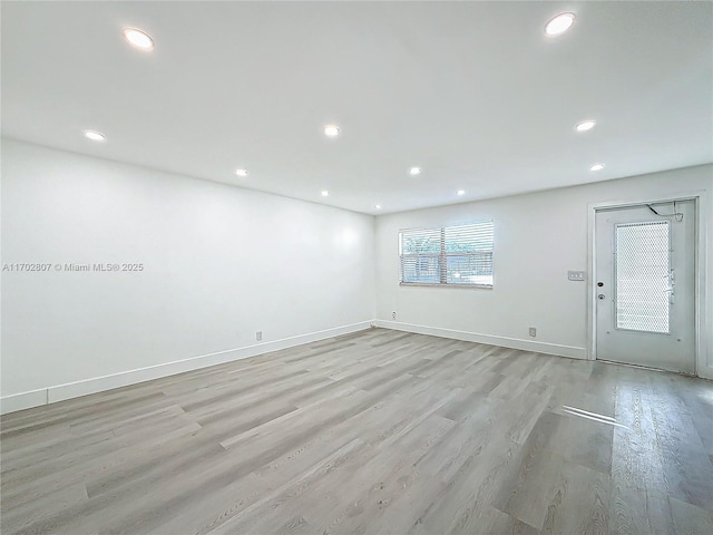 empty room with recessed lighting, light wood-style flooring, and baseboards