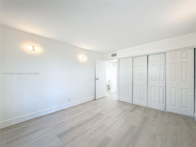 unfurnished bedroom featuring a closet and light hardwood / wood-style flooring