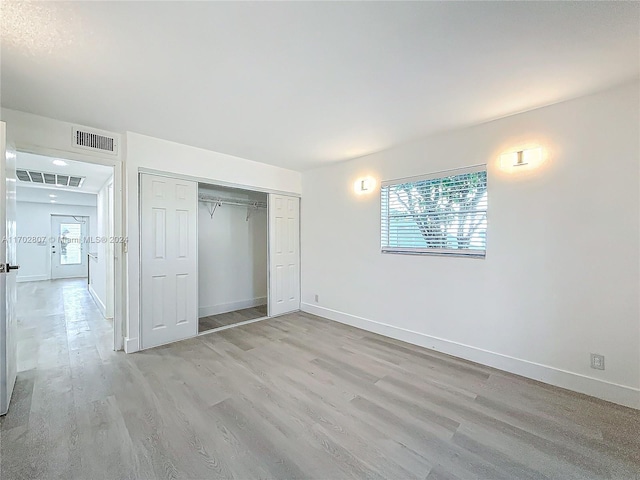 unfurnished bedroom featuring a closet and light hardwood / wood-style flooring