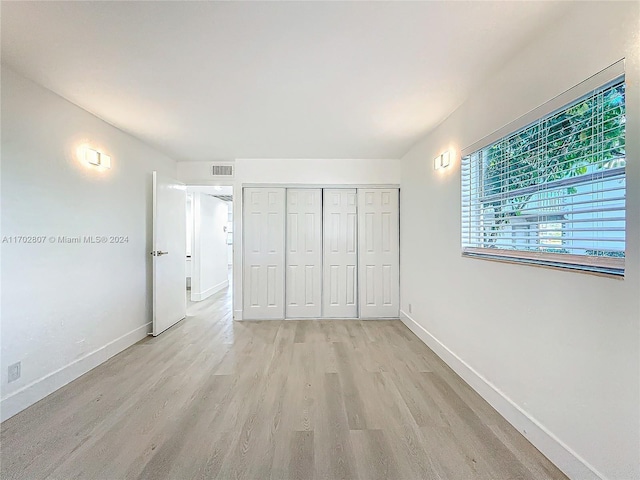 unfurnished bedroom featuring light hardwood / wood-style floors and a closet