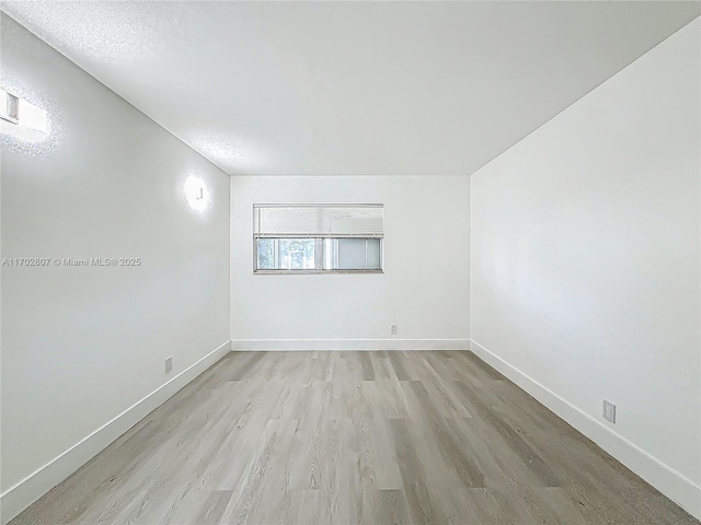 unfurnished room with light wood finished floors and baseboards