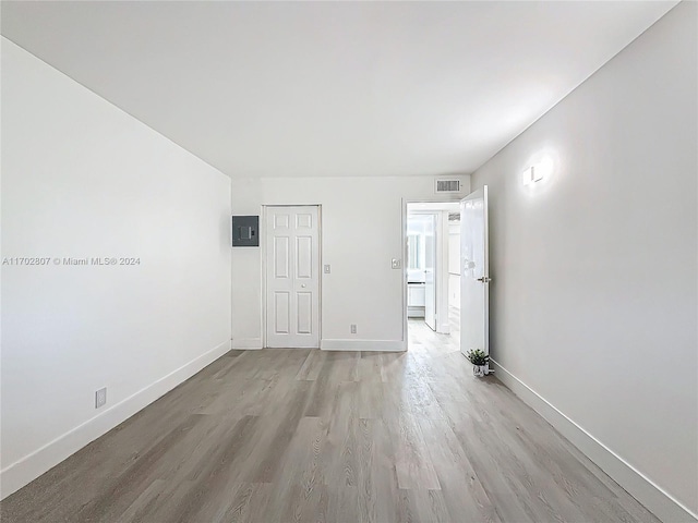 unfurnished room featuring light wood-type flooring and electric panel