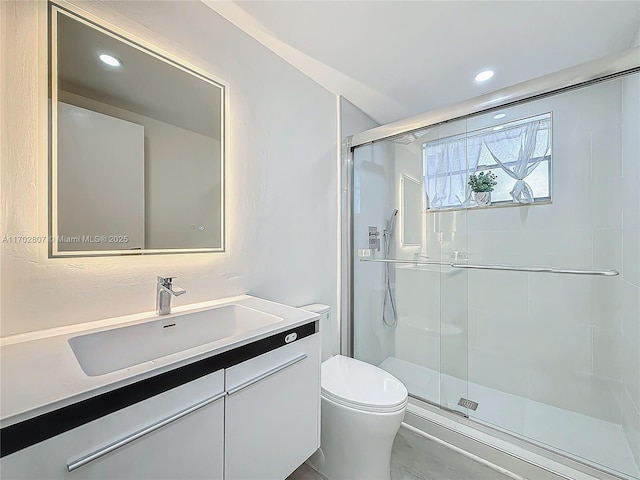 bathroom with a shower stall, toilet, vanity, and recessed lighting