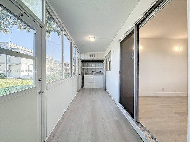 corridor featuring washing machine and clothes dryer and light hardwood / wood-style floors