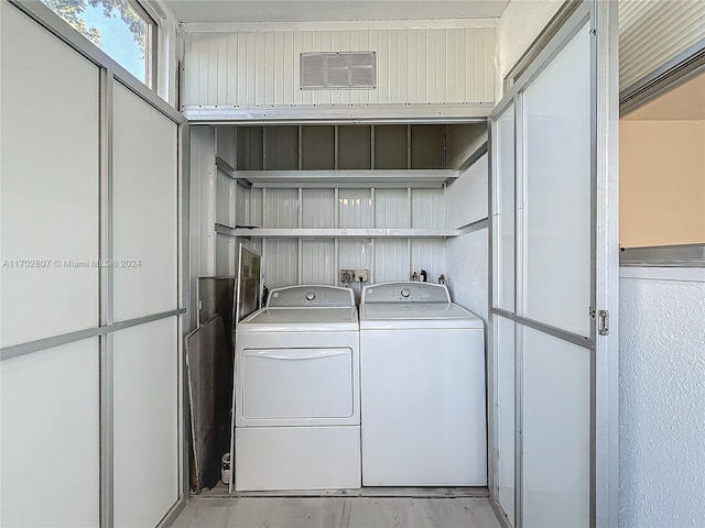 laundry area with light hardwood / wood-style floors and washing machine and dryer