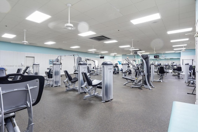 exercise room with a drop ceiling and a ceiling fan