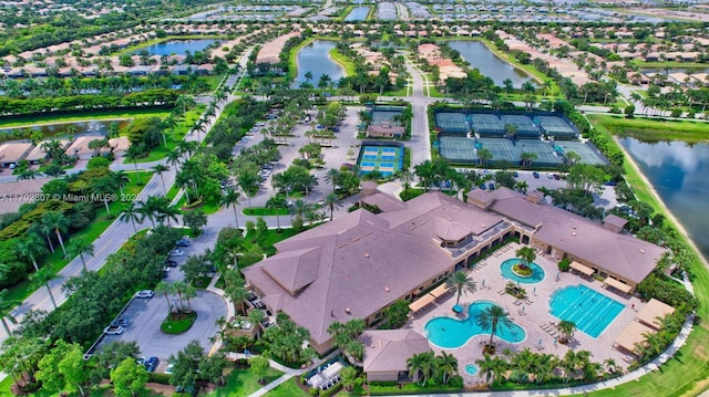 aerial view of property and surrounding area with a large body of water, a pool, and nearby suburban area