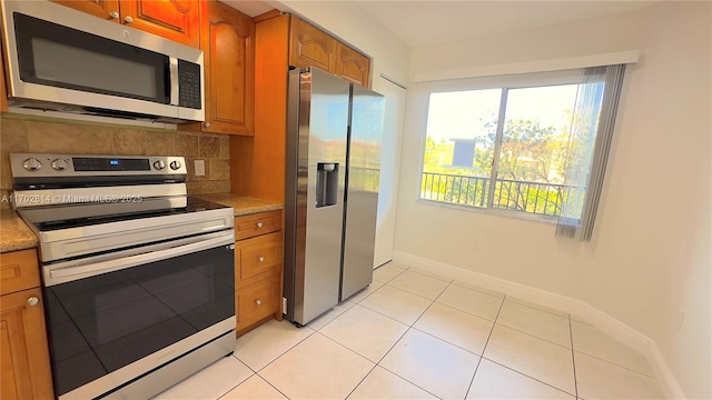 kitchen featuring light tile patterned flooring, appliances with stainless steel finishes, and decorative backsplash