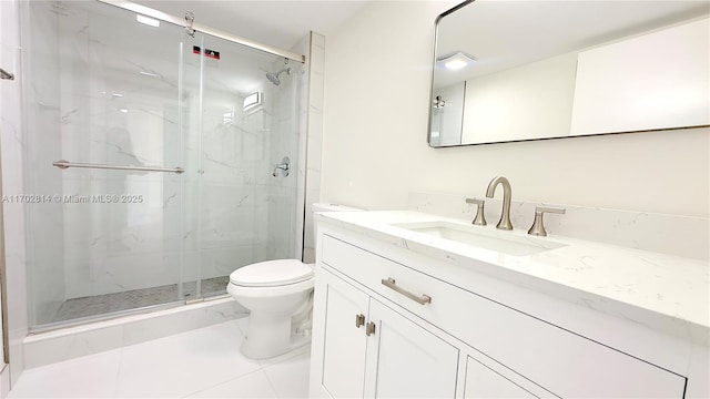 bathroom featuring vanity, a shower with shower door, and toilet