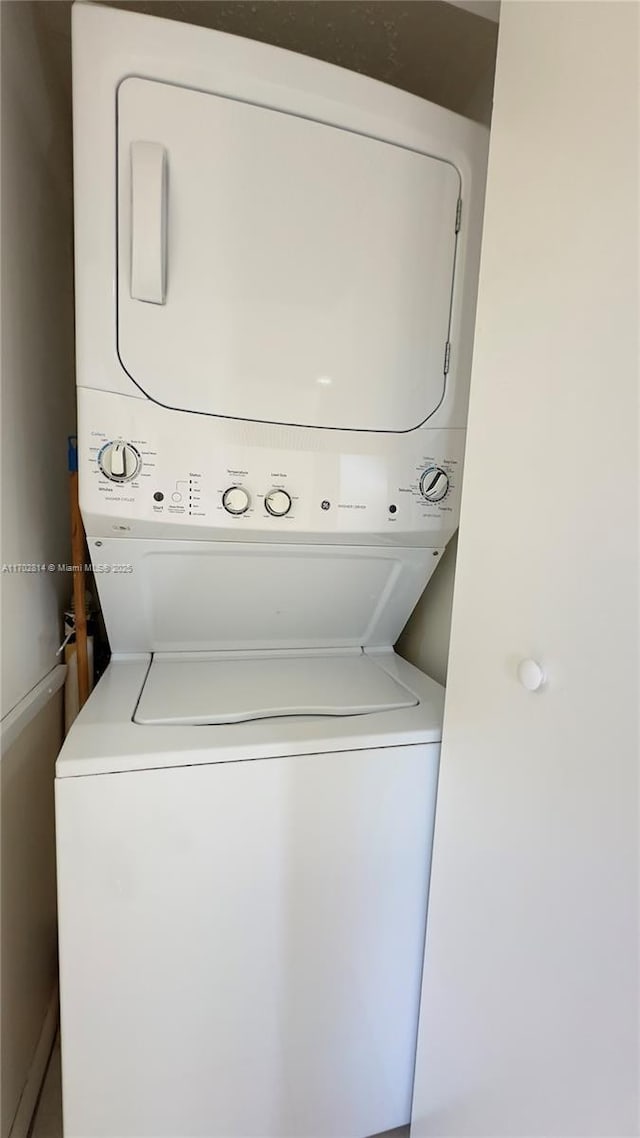 clothes washing area featuring stacked washer and clothes dryer