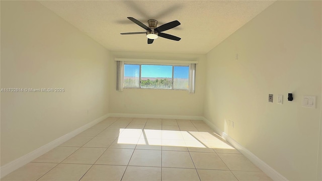 tiled empty room featuring ceiling fan and a textured ceiling