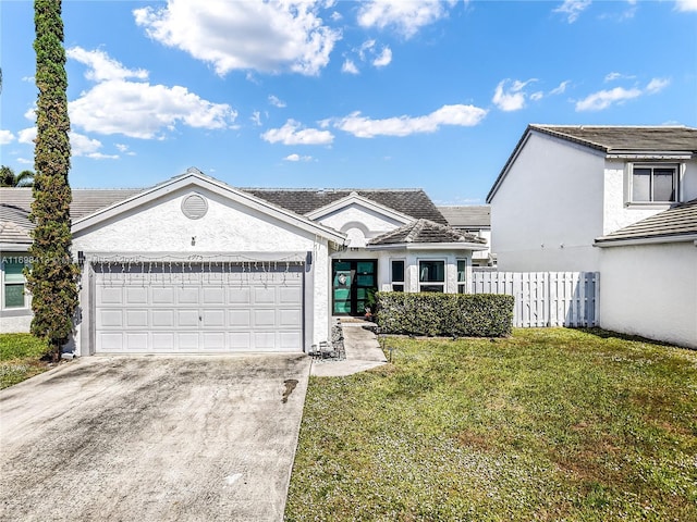 view of front of house with stucco siding, an attached garage, fence, driveway, and a front lawn