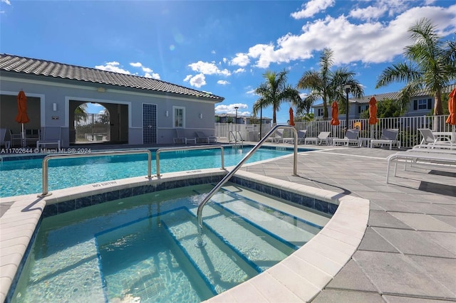 view of swimming pool with a patio area and a community hot tub