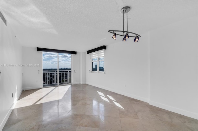 3000 Coral Way Unit 1502, Miami, FL 33145 - spare room featuring baseboards, a textured ceiling, a chandelier, and tile patterned floors