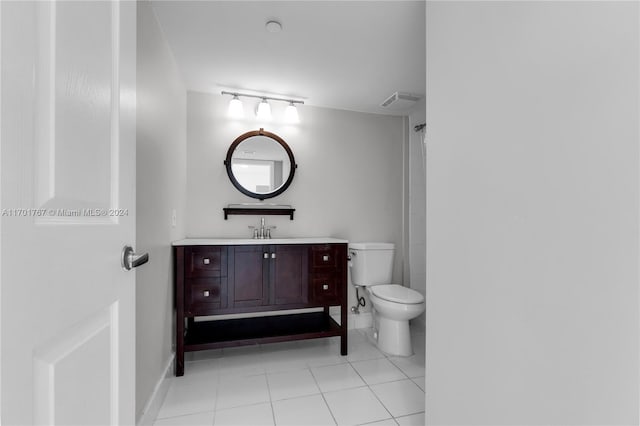 bathroom with tile patterned flooring, vanity, and toilet