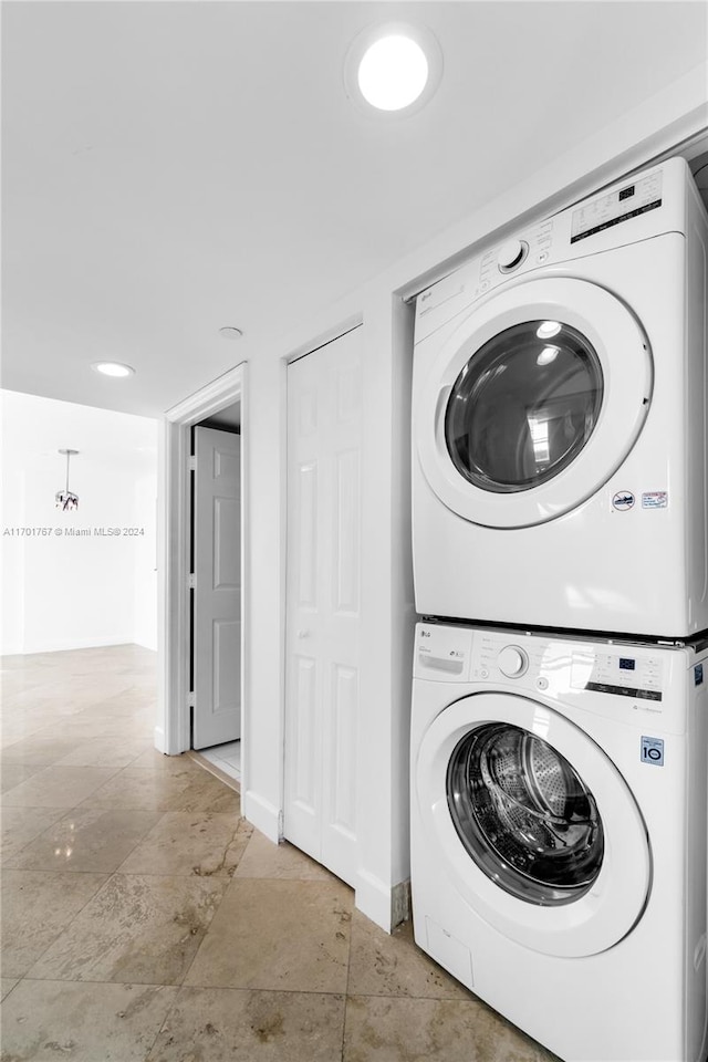 washroom featuring stacked washer / dryer and light tile patterned floors