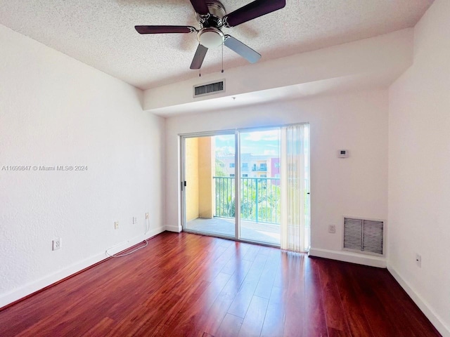 unfurnished room featuring ceiling fan, dark hardwood / wood-style flooring, and a textured ceiling