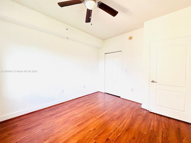 spare room with ceiling fan, wood-type flooring, and a textured ceiling