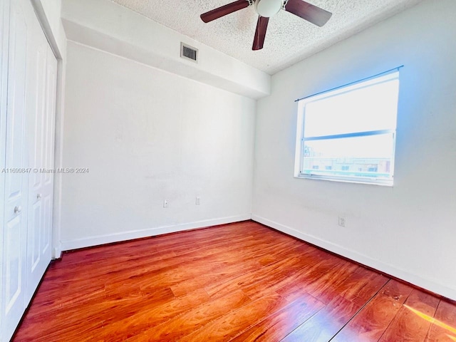 spare room with ceiling fan, hardwood / wood-style floors, and a textured ceiling