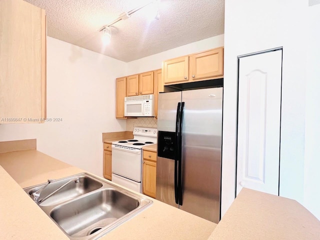 kitchen featuring light brown cabinets, white appliances, backsplash, track lighting, and sink