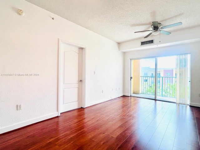 unfurnished room with a textured ceiling, dark hardwood / wood-style floors, and ceiling fan