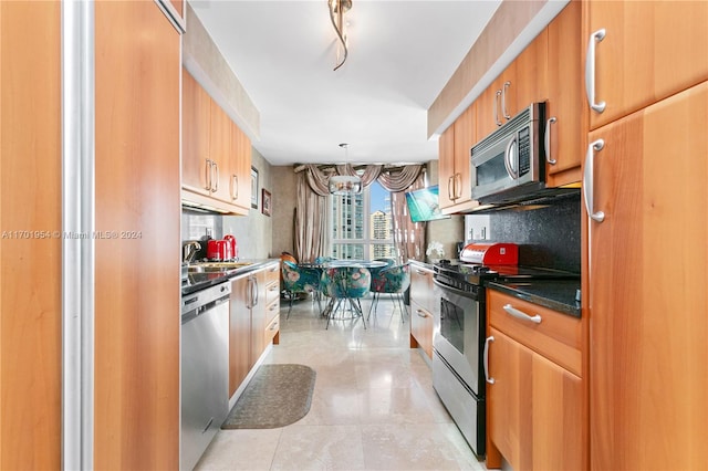 kitchen with backsplash, sink, decorative light fixtures, appliances with stainless steel finishes, and a notable chandelier